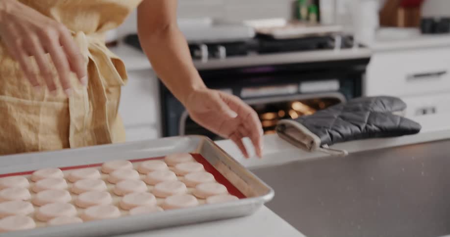 A woman is cooking food and talking on her cellphone