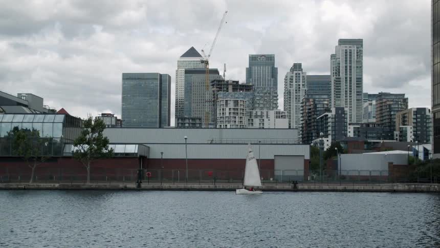 A ship sails with skyscrapers in the background