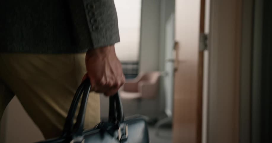 A man is walking into an office and holding a bag
