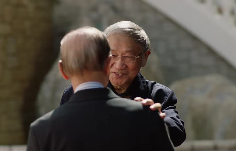Two men are talking to each other outdoors during the daytime