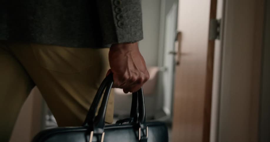 An employee is walking into an office building during the day