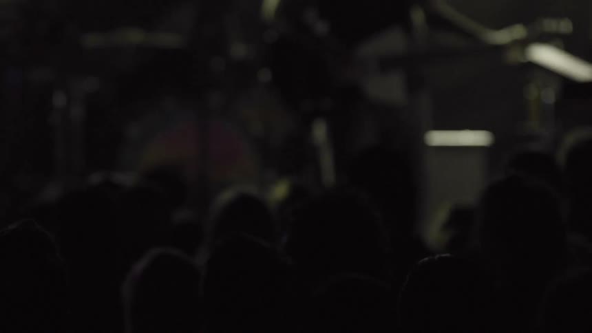 A crowd watches a band play a concert