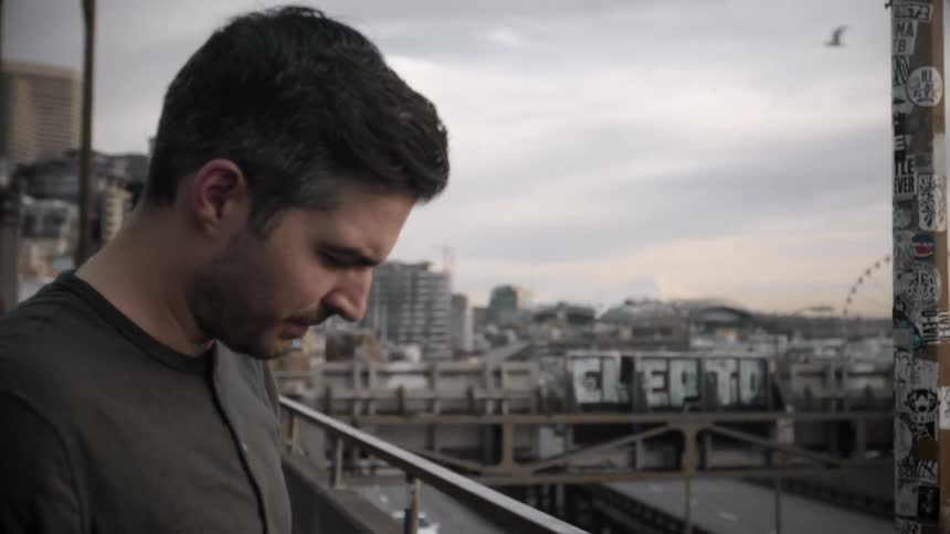 A dark haired man is looking down