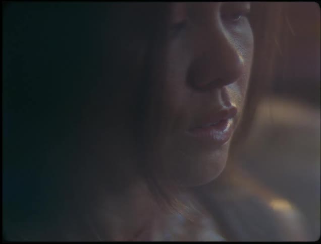 Sunlight is shining on an asian woman who is wearing a black tank top and sweating