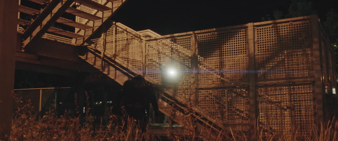 Two men are getting into a fight outdoors at night