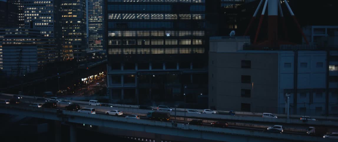 Vehicles drive in and out of downtown at night