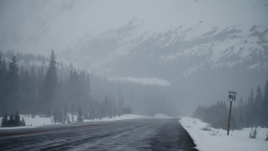 A snow storm is forming in a mountain road