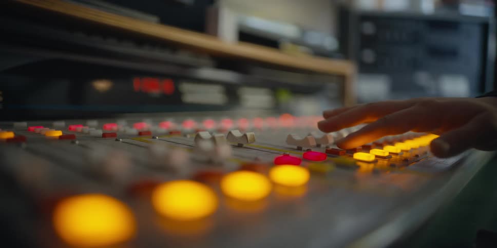 A person presses the switches on the sound board
