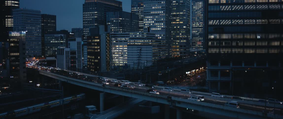 Vehicles drive on the bridge and through town