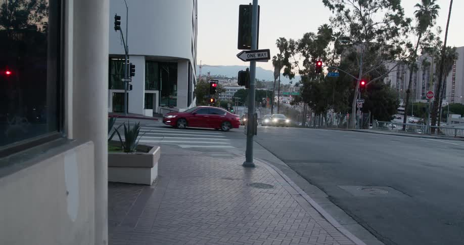 Vehicles move through city intersection with mountain in the background