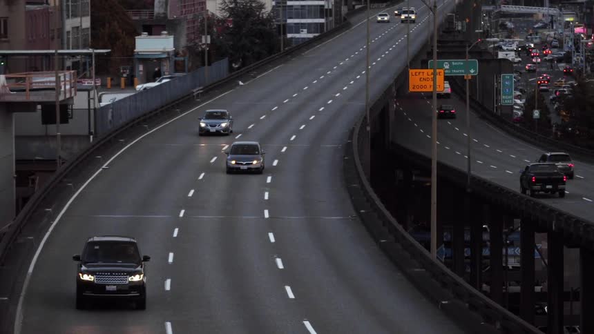 Cars drive on a freeway at dawn