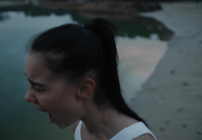 A woman screams out loud while standing on the beach