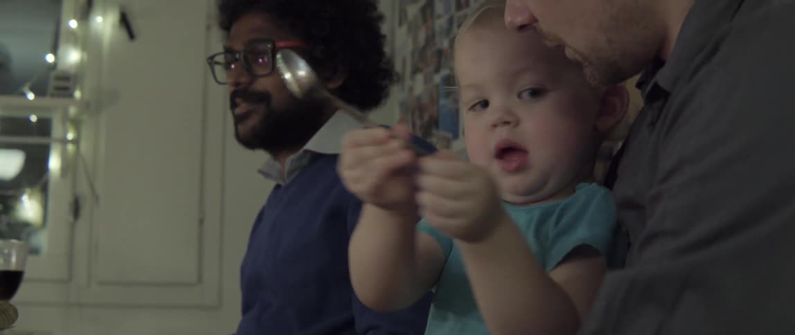 Boy picking up a spoon at table with curious everyday moment