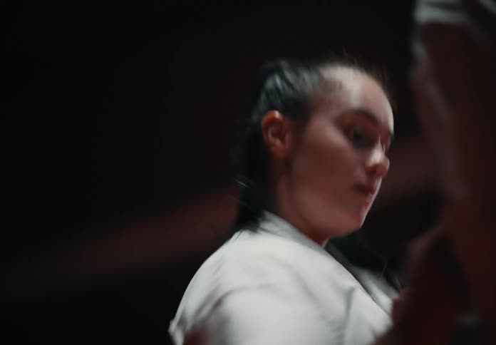 A woman is fighting an opponent in a martial arts match