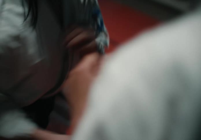 Two martial arts students spar on mats in a dojo