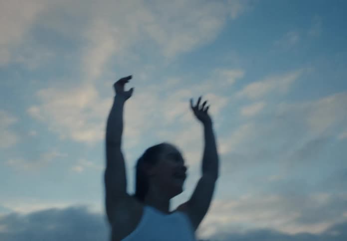 A dynamic handheld shot of a female athlete throwing her hands in the air to celebrate a victory