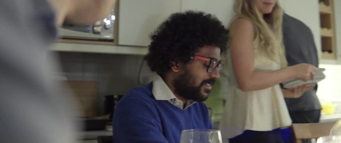 Man Talking at a Dining Room Table With Warm Conversation and Engaged Expression