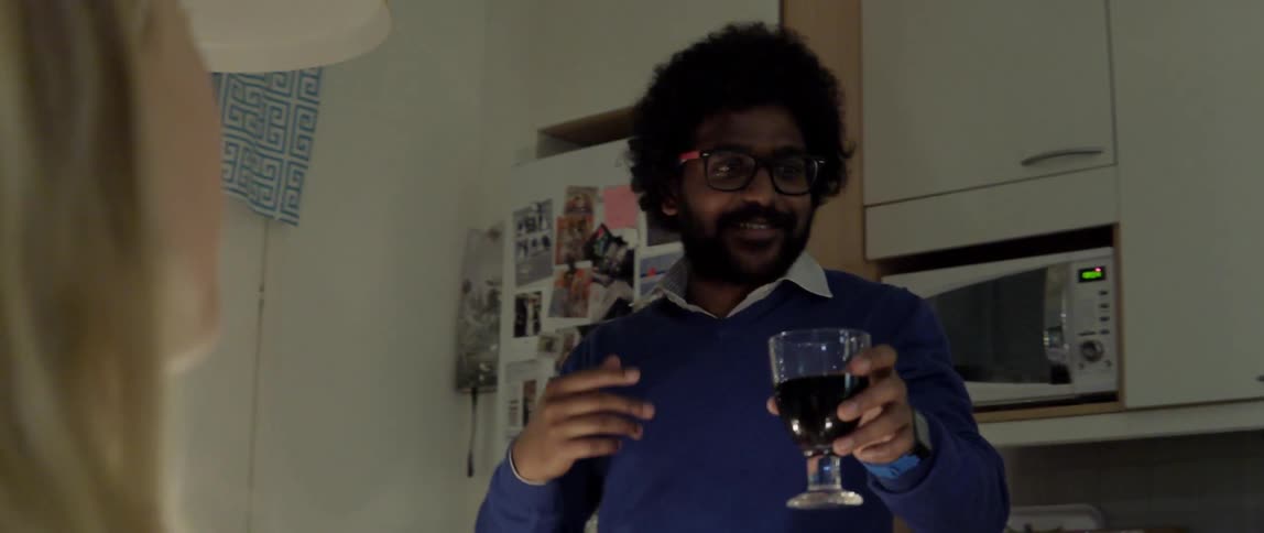 Man tapping his glass to give a toast during a festive evening dinner party.