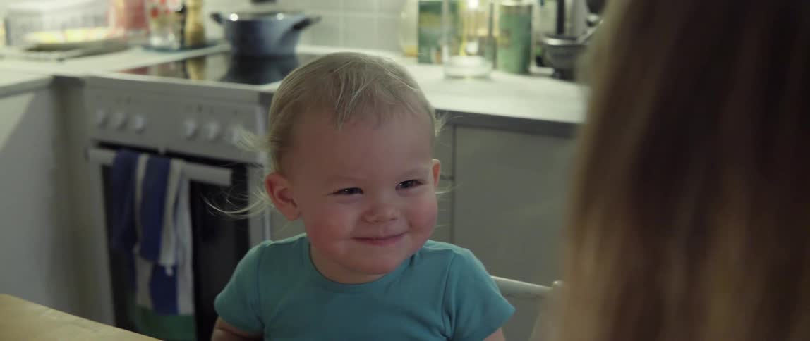 Toddler Sitting in a Highchair Laughing and Smiling With Pure Playful Joy