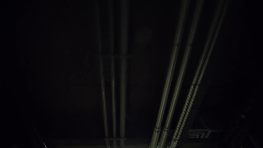 The corridor is lined with pipes