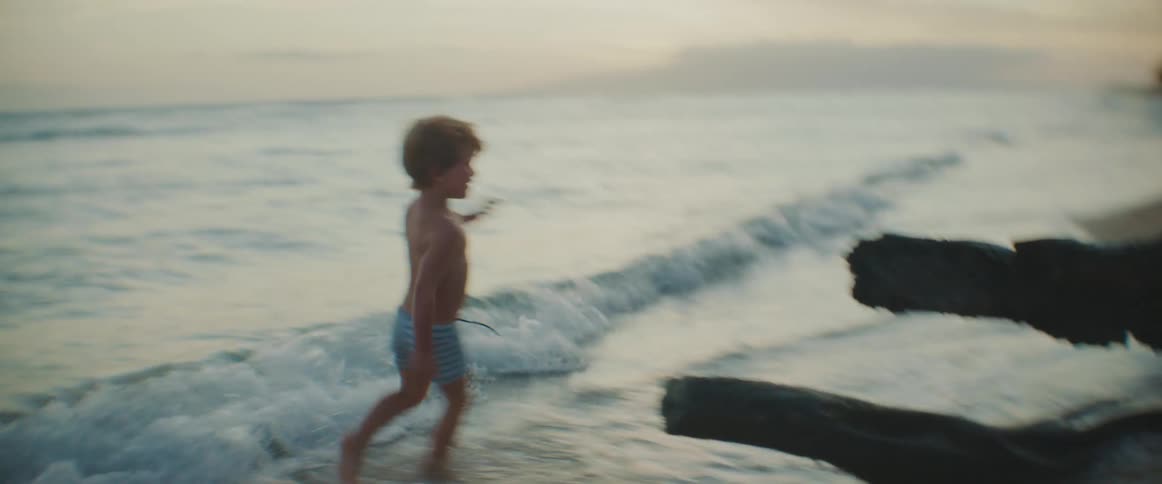 A boy chases a pair of girls around a beach