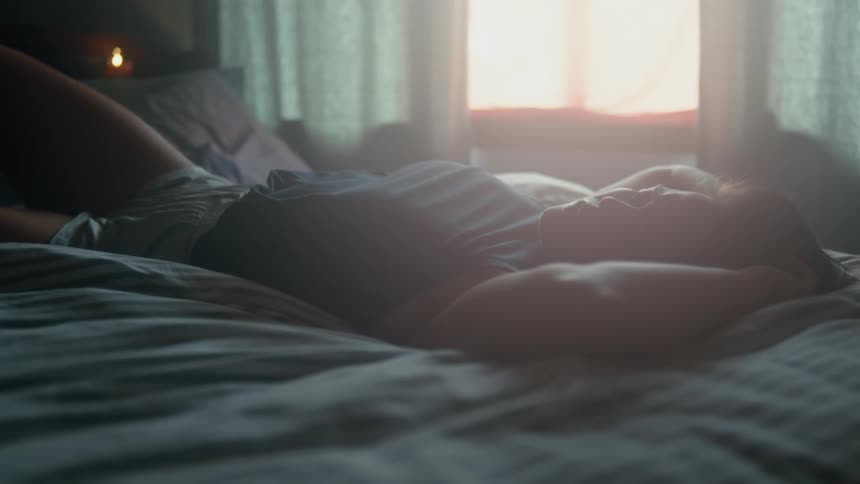 A teenage girl lies in bed