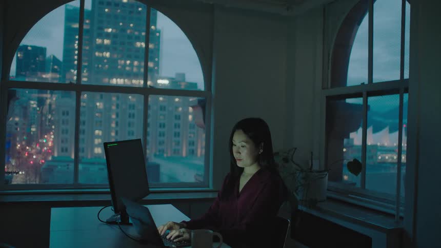 An asian woman is working in a office indoors in the city