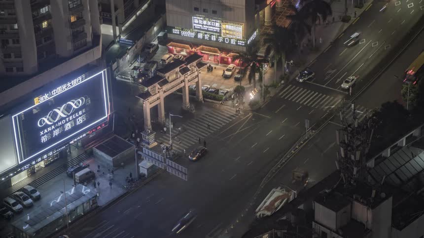 Pedestrians and traffic move through a dark city night