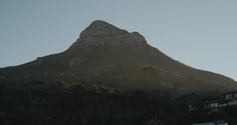 A single mountain top rises over a building