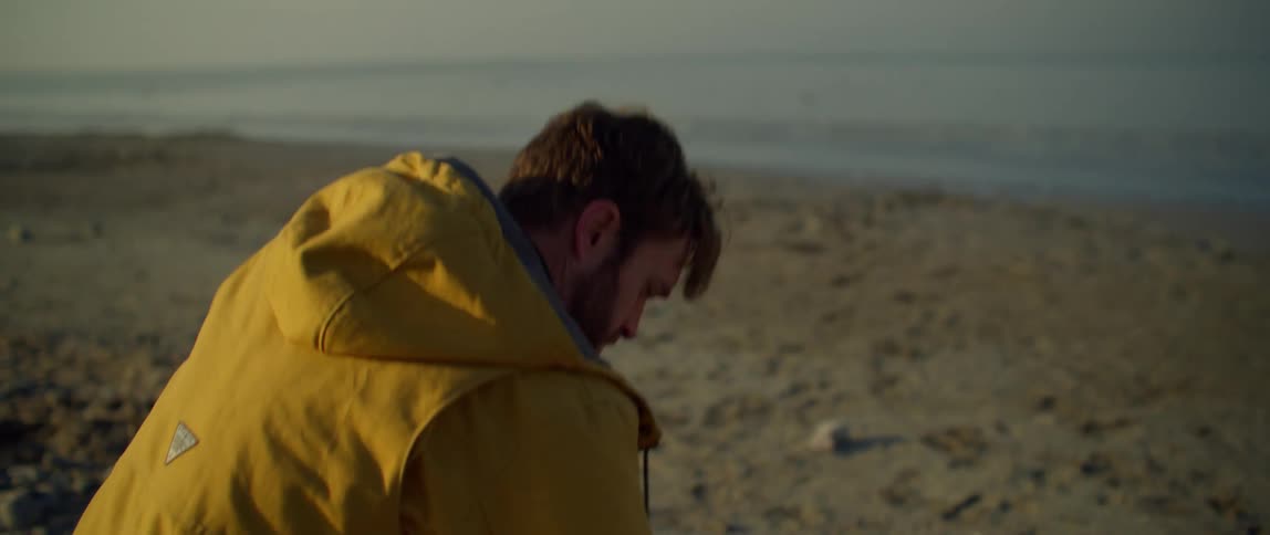 A man throws a rock on the beach