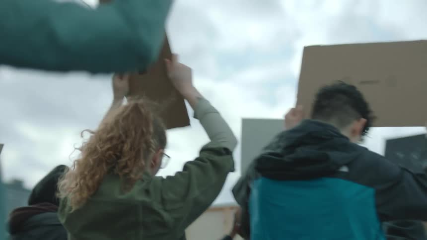 Protesters march together with signs