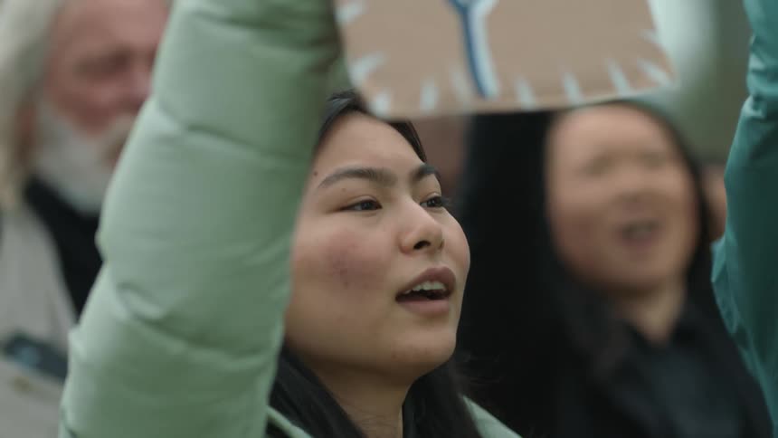Protesters yell and wave signs above their heads