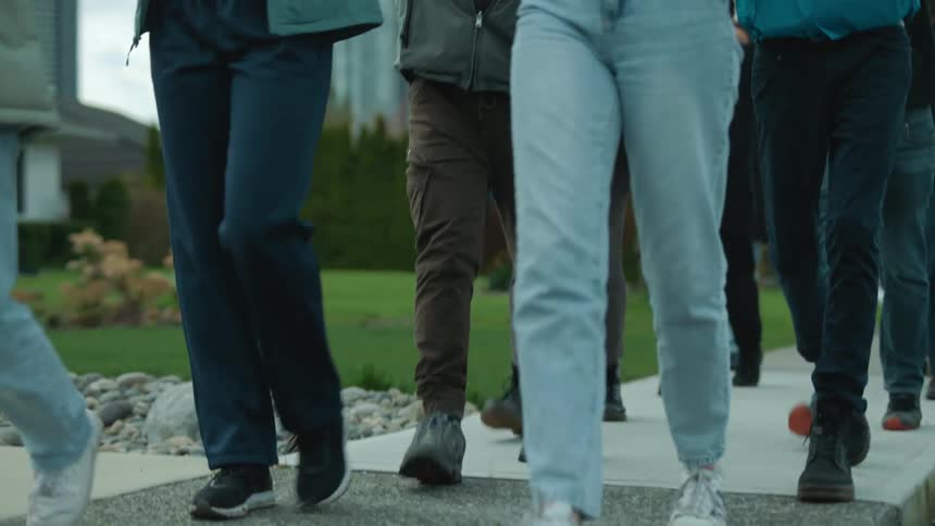 A group of people march down a sidewalk to protest climate change