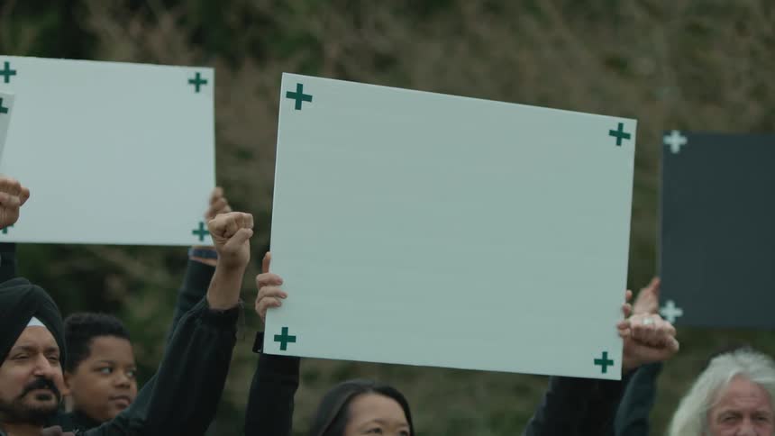 Protestors hold up signs