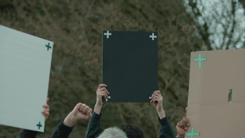 Protesters stand and hold hands above their heads