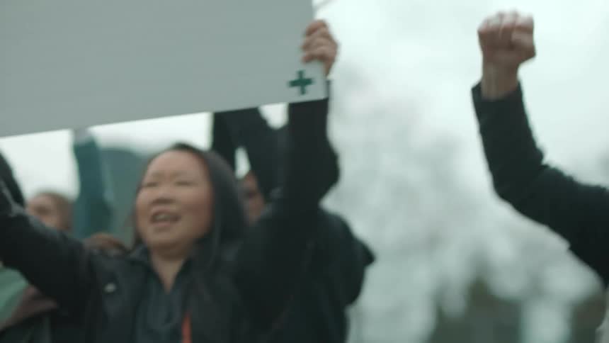 Protesters holding up signs demonstrate in the street