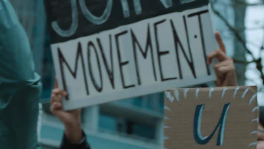 Protesters march carrying signs