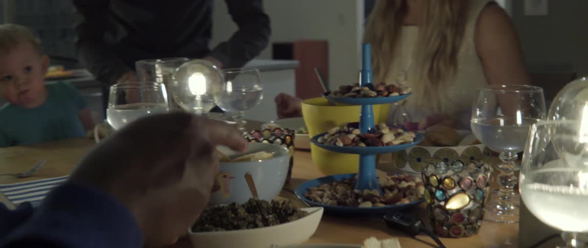 People serve themselves and interact at a table full of food