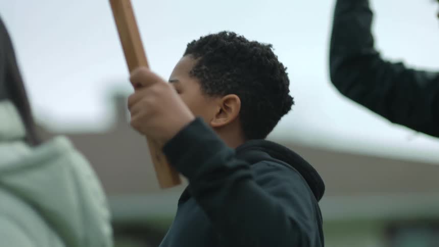 A group of protestors march with signs and megaphones through a neighborhood