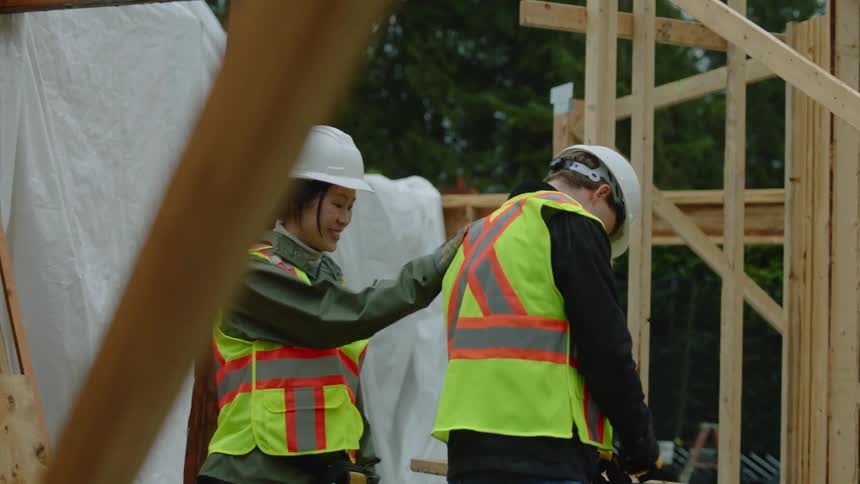 A female construction worker checks on a coworker at the job site
