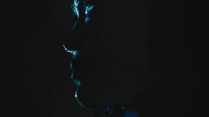 Glowing rings shine in front of a womans face