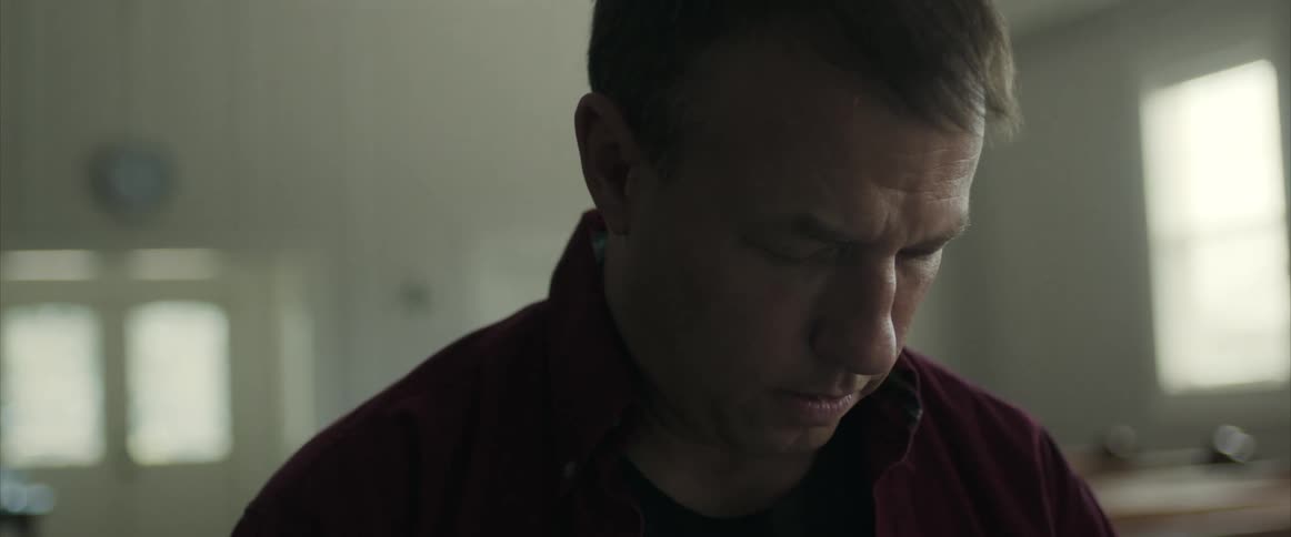 Man bowing head in prayer in empty church