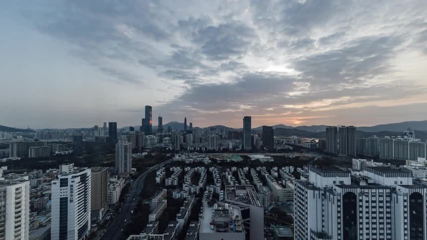 Aerial view of traffic driving through a downtown area at dusk