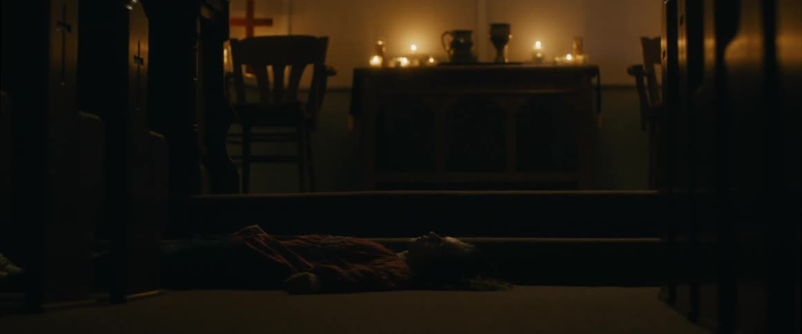 Teenager lies on the floor at the front of a church