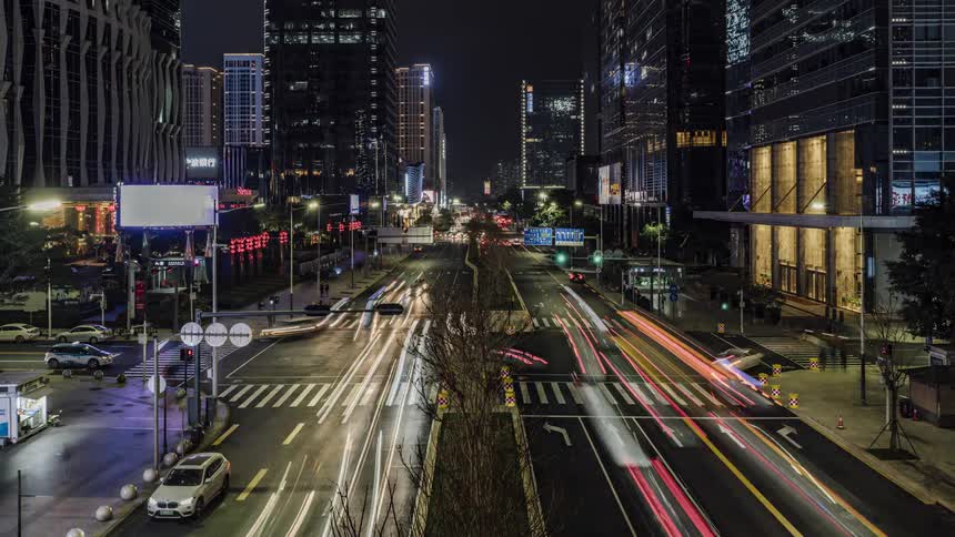 Traffic travels along a large intersection in a metropolis at night