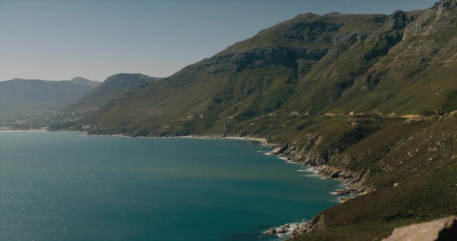 Town sits on vegetation covered mountain slopes bordering ocean shore