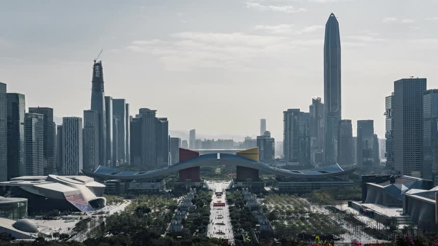 People walking through and around the urban park in shenzhen china with the imposing city skyline behind