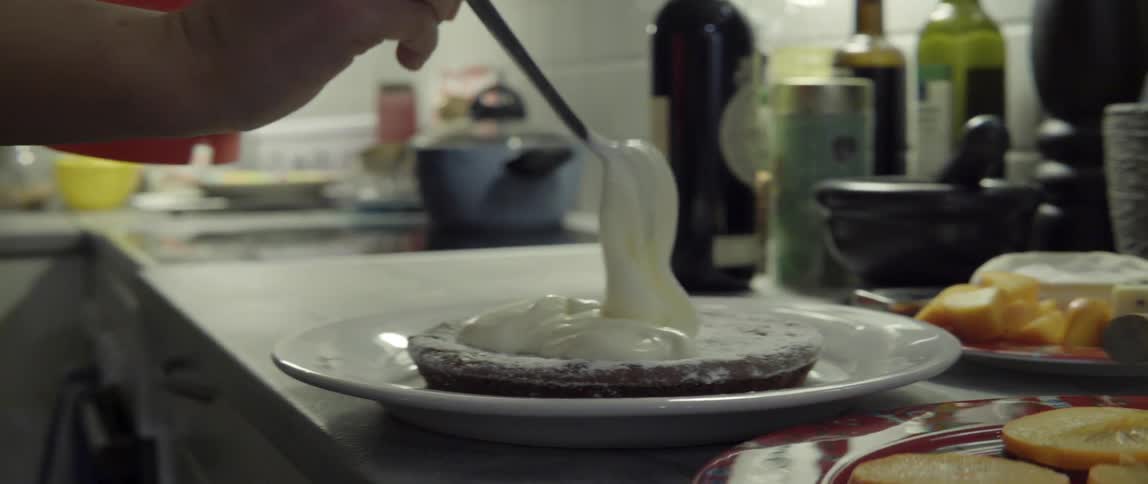 Fresh Cream Being Piped Into a Pastry in a Calm and Satisfying Kitchen Moment.
