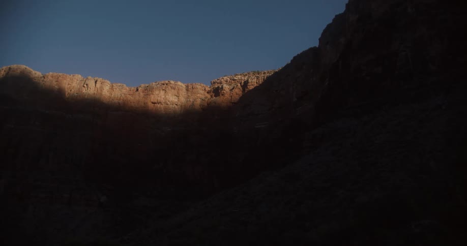 A large shadow is cast on the inside of a canyon