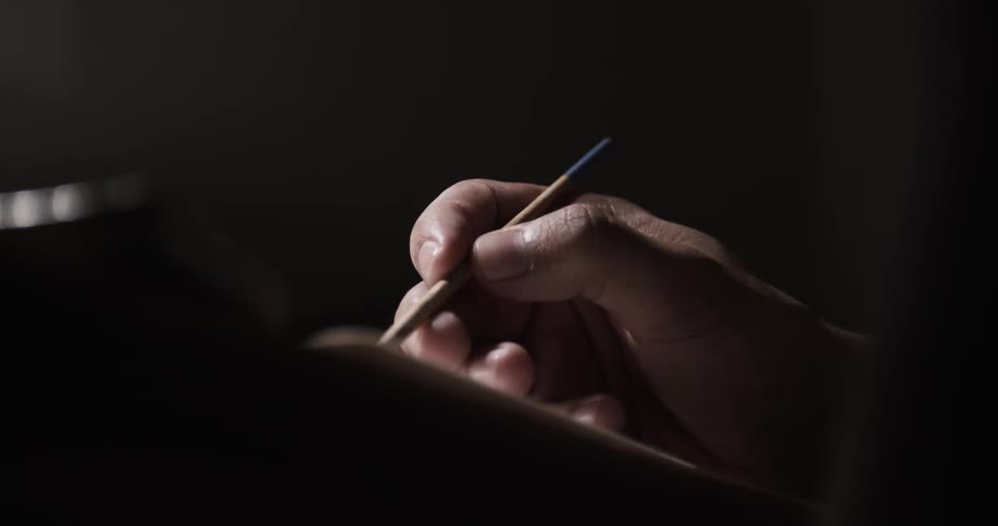 A view of a person writing with a pencil